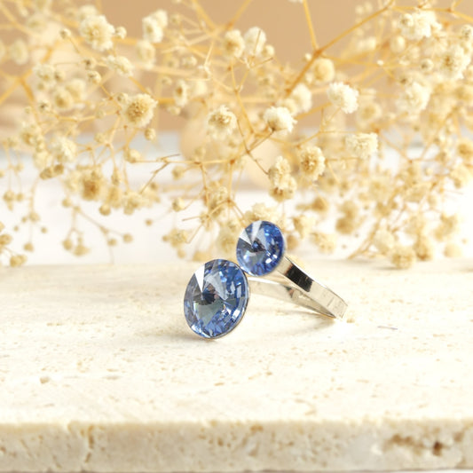 Bague ornée de deux cristaux de couleur Saphir clair.