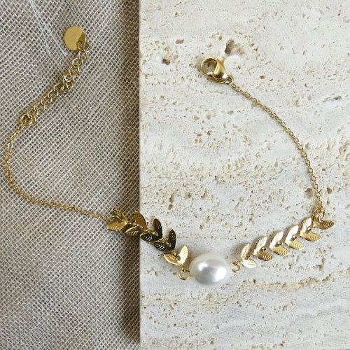 bracelet. plumes dorés et perle blanche