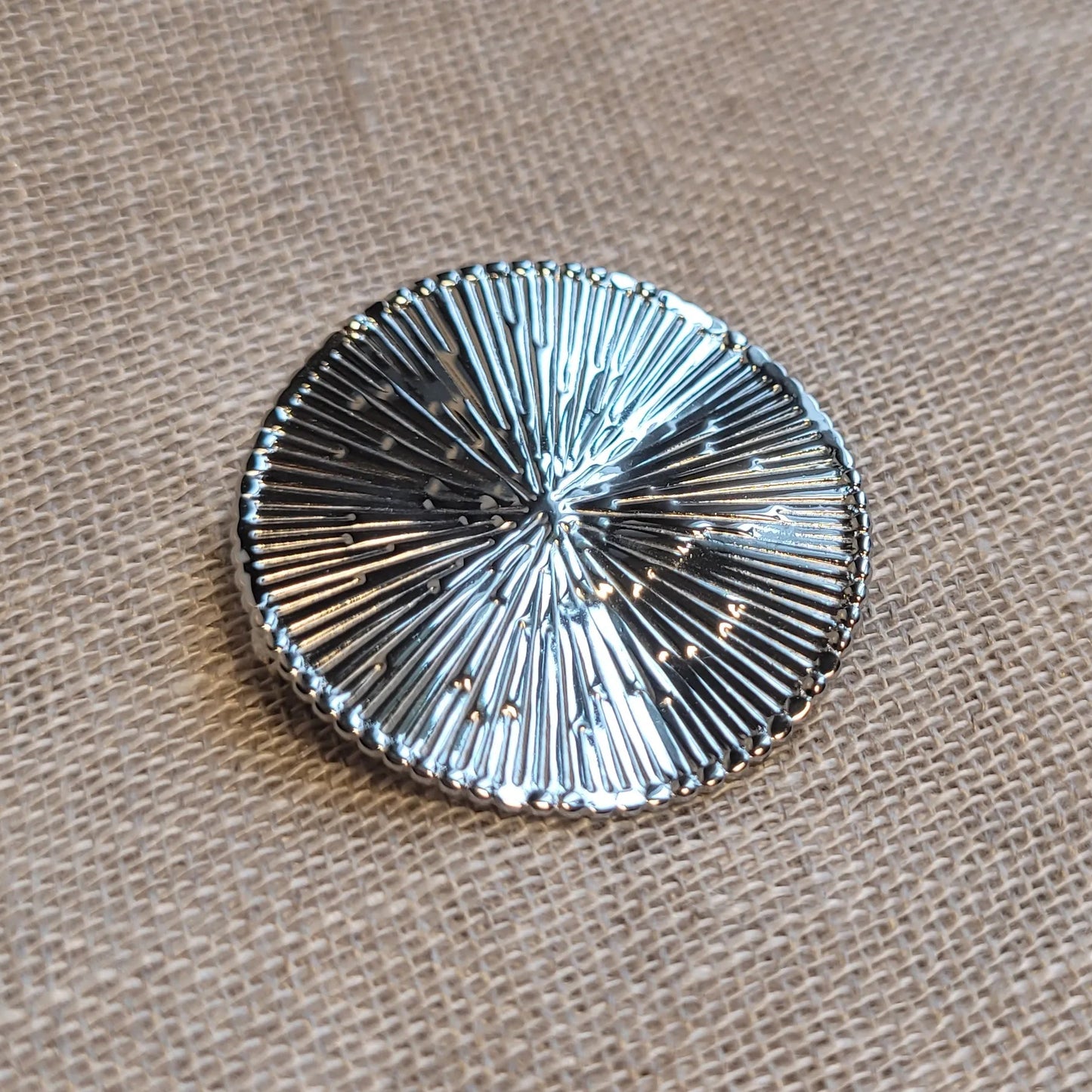 une broche argentée Héméra de luxe au design solaire