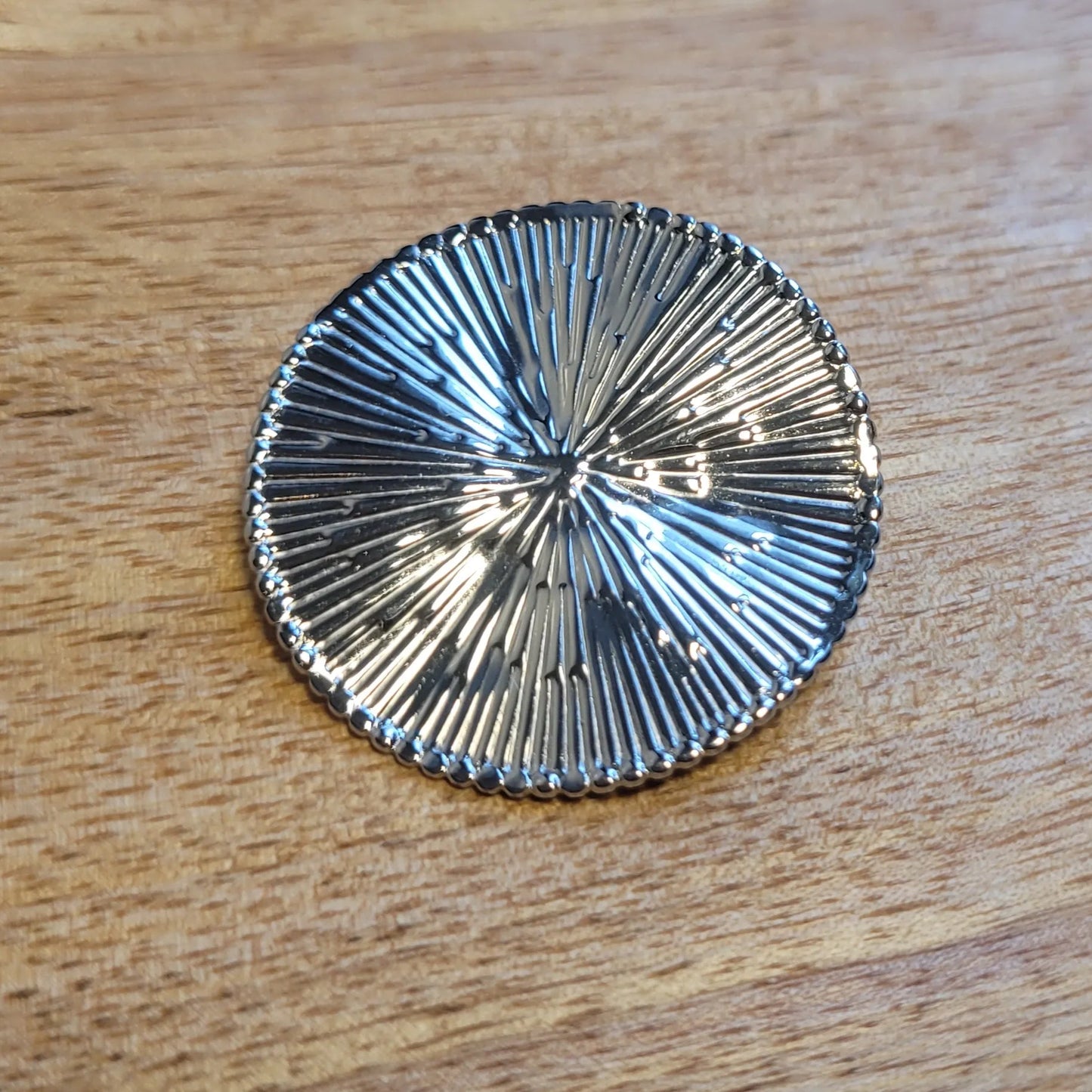 une broche argentée Héméra au design solaire pour sublimer un petit haut