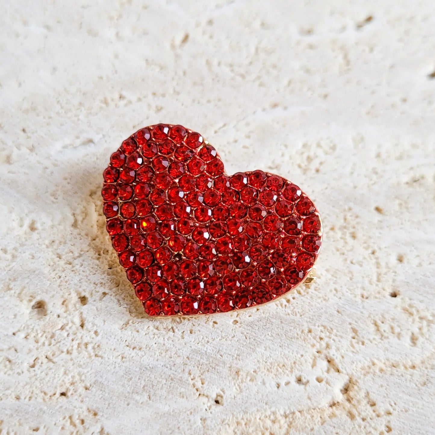 une broche dorée Amour en cœur de strass rouges pour sublimer un petit haut