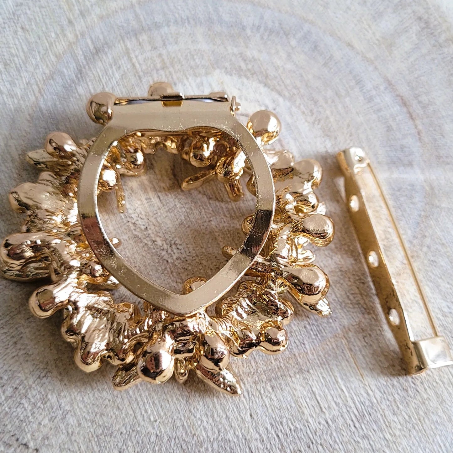 une broche dorée Aurélis de luxe en couronne de strass et papillons