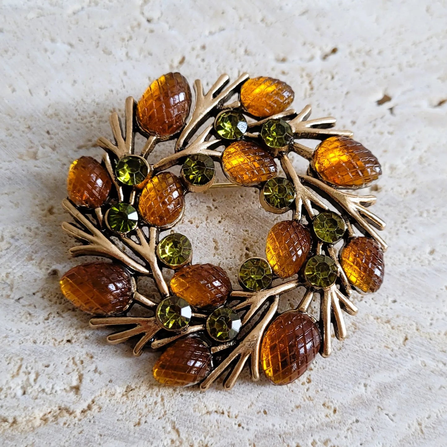 une broche dorée Autumn en couronne de strass aux teintes automnales pour sublimer un petit haut