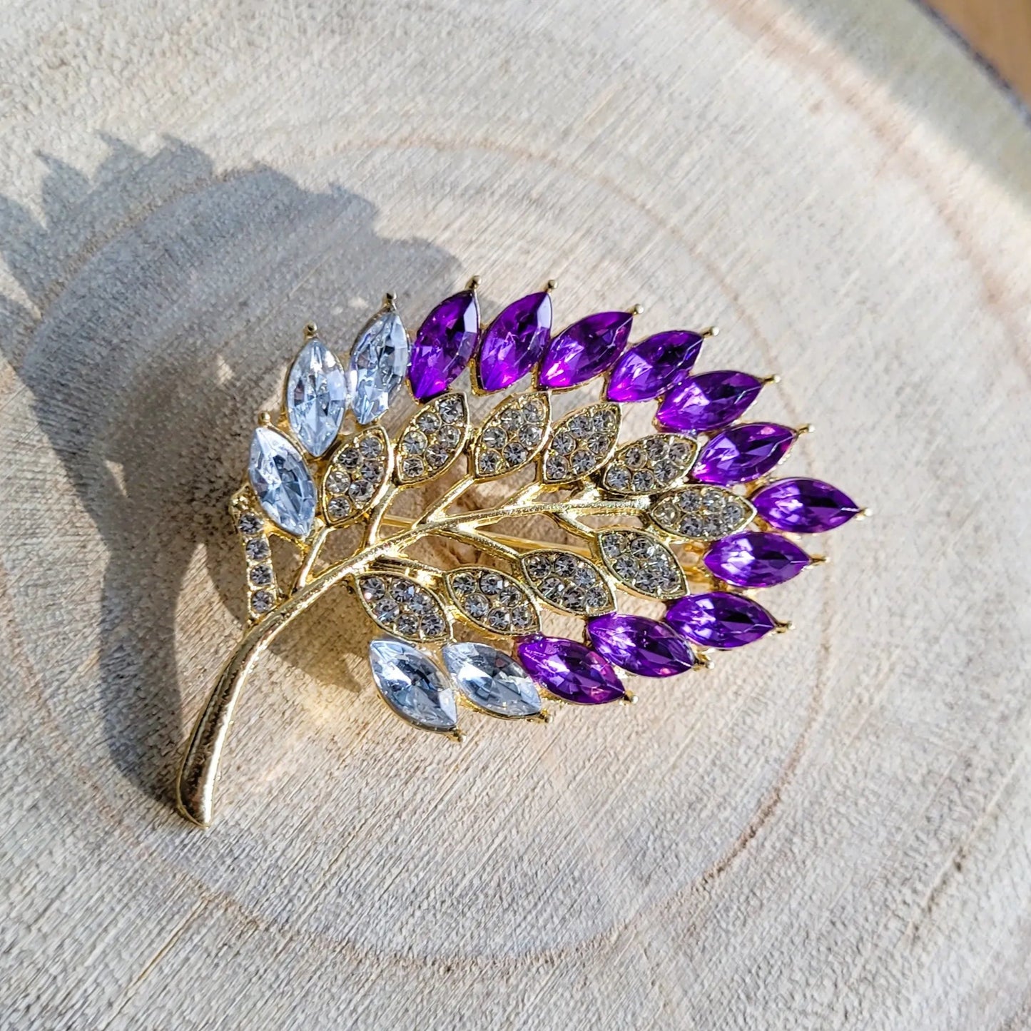 une broche dorée Botanika de luxe d’une feuille strass élégante