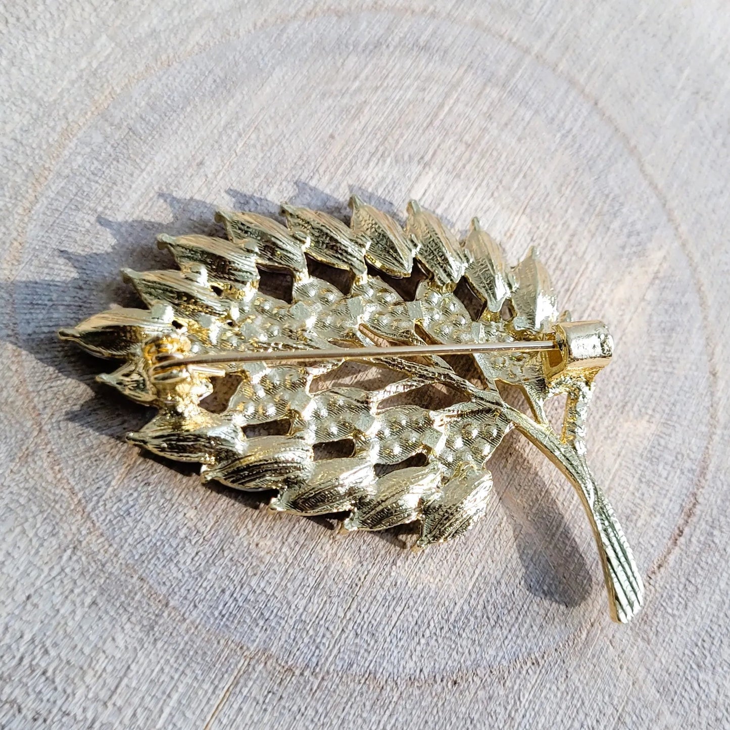 une broche dorée Botanika d’une feuille strass élégante pour sublimer un petit haut