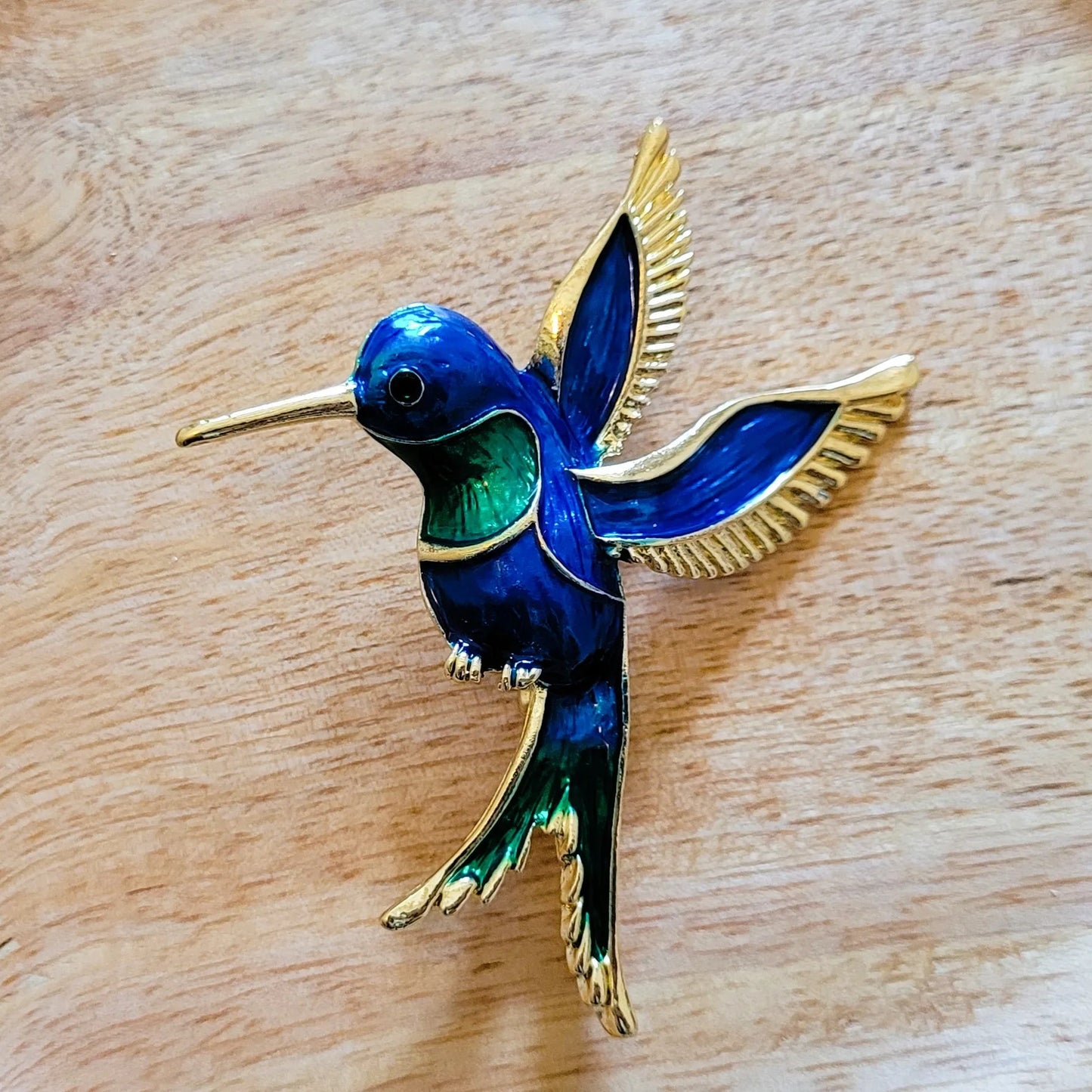 broche dorée Calliope, une broche colibri en vol pour vêtement de femme