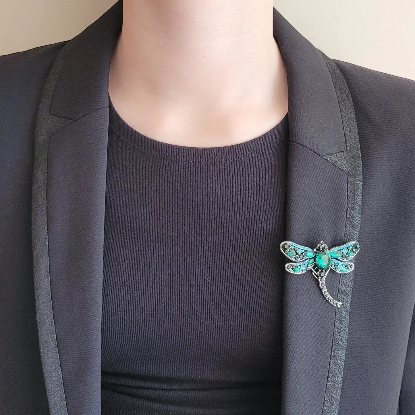 une broche dorée Demoiselle de luxe d’une libellule ornée de strass verts