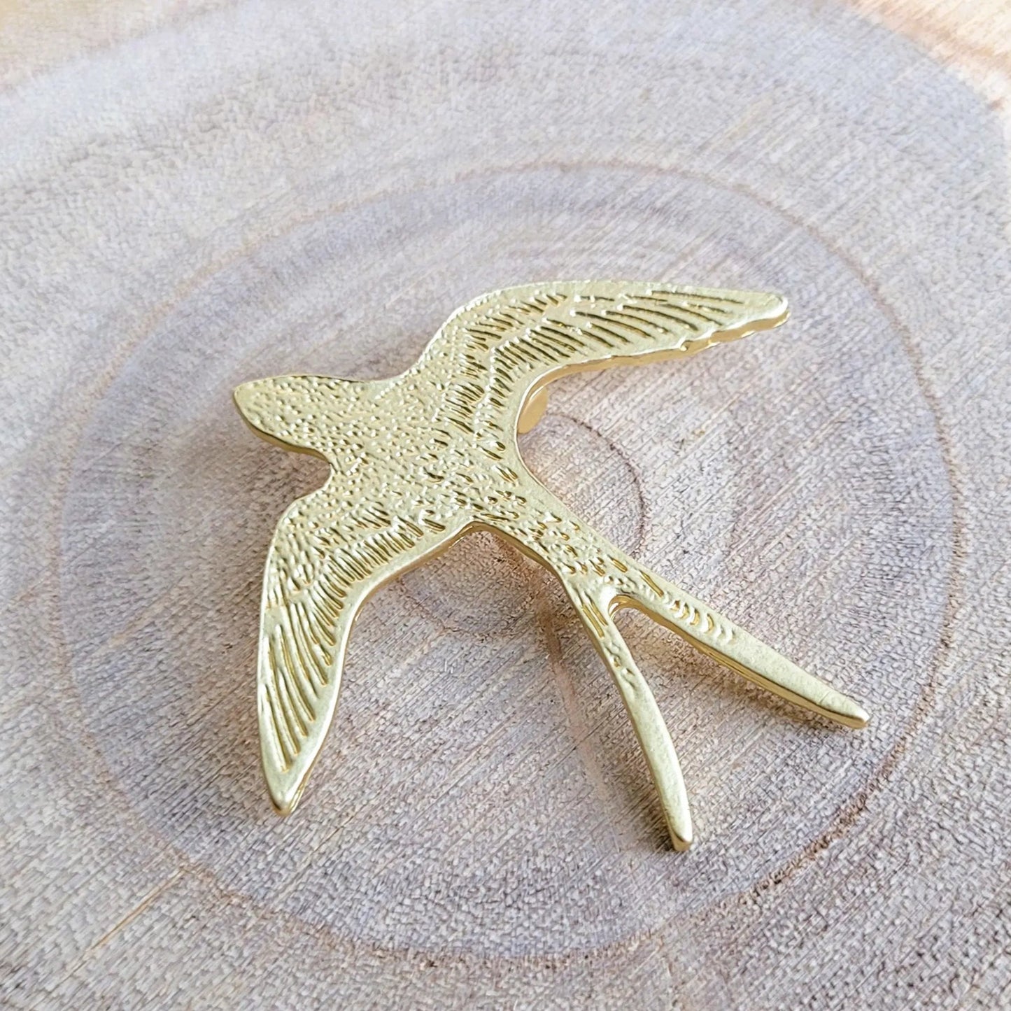 une broche dorée Hyrondel de luxe d’une hirondelle texturée