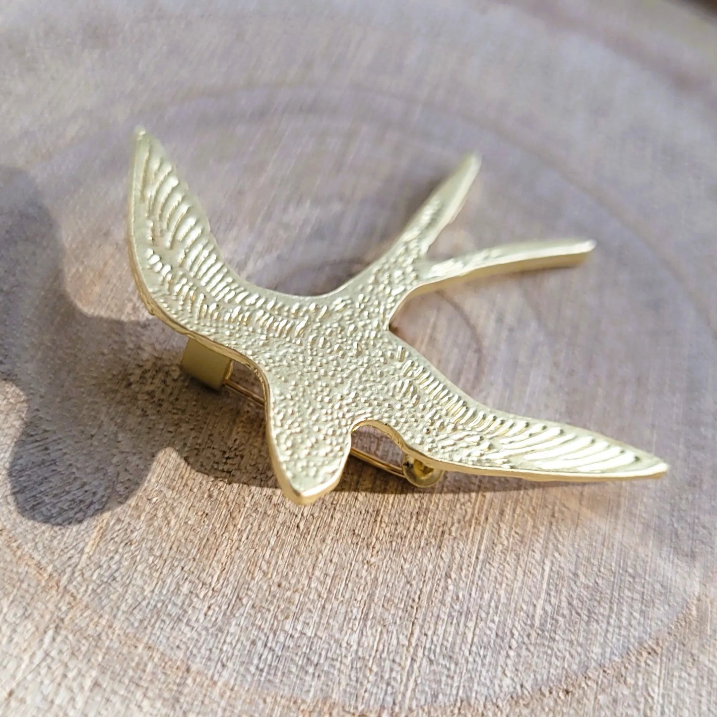 une broche dorée Hyrondel d’une hirondelle texturée pour sublimer un petit haut