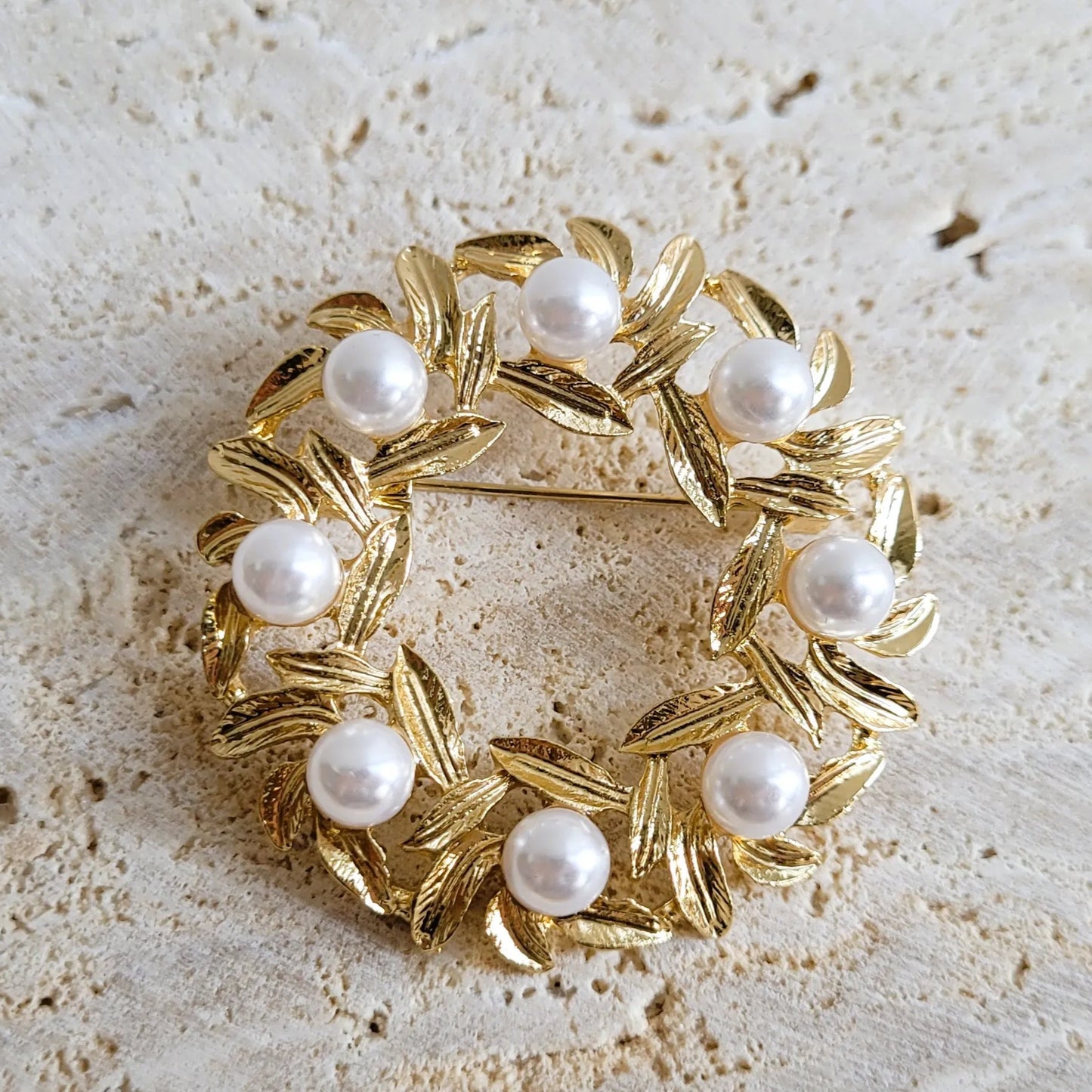 broche dorée Lauréa, un bijou moderne en forme de couronne de feuilles de laurier et perles nacrées