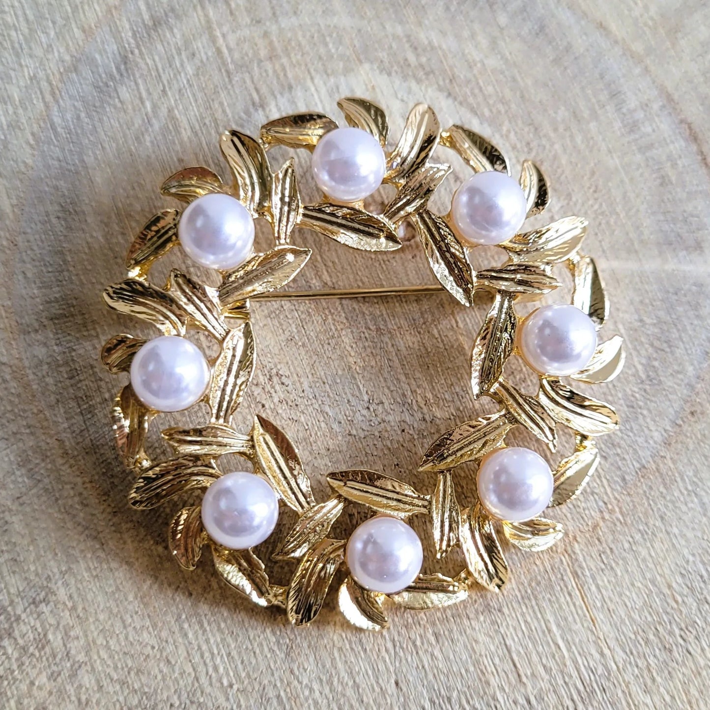 une broche dorée Lauréa de luxe en couronne de feuilles de laurier et perles nacrées