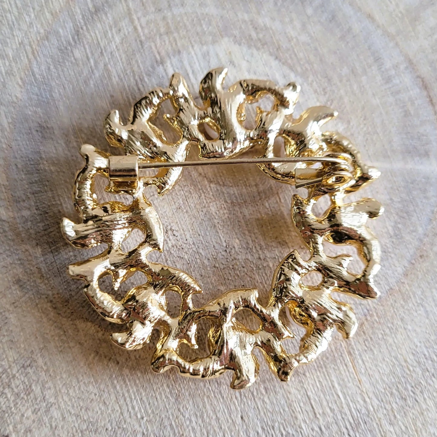 une broche dorée Lauréa en couronne de feuilles de laurier et perles nacrées pour sublimer un petit haut
