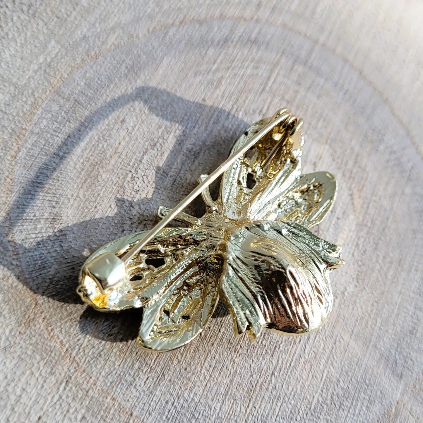 une broche dorée Maya d’une élégante abeille ornée de strass pour sublimer un petit haut