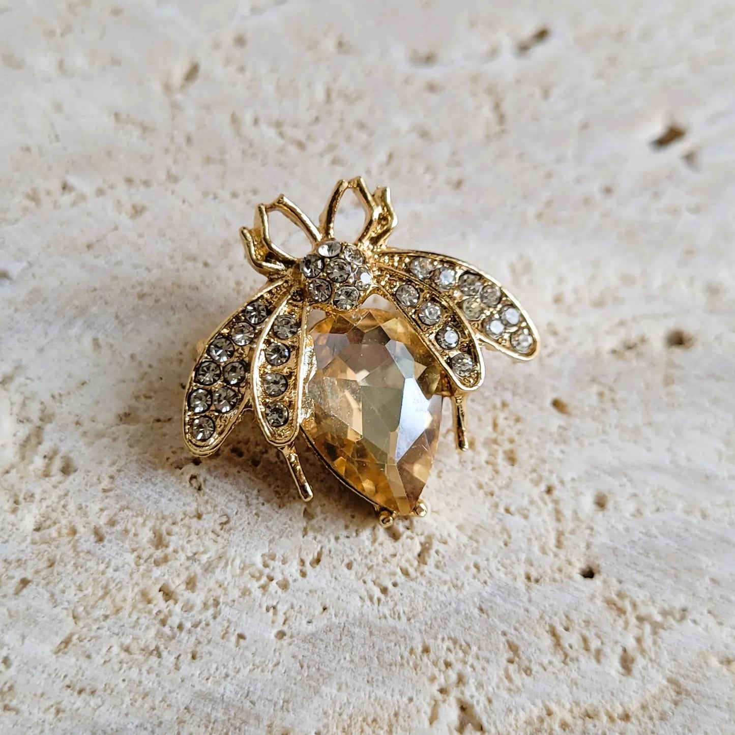 broche dorée Mellya, une broche d’une abeille ornée d’un strass nude pour vêtement de femme