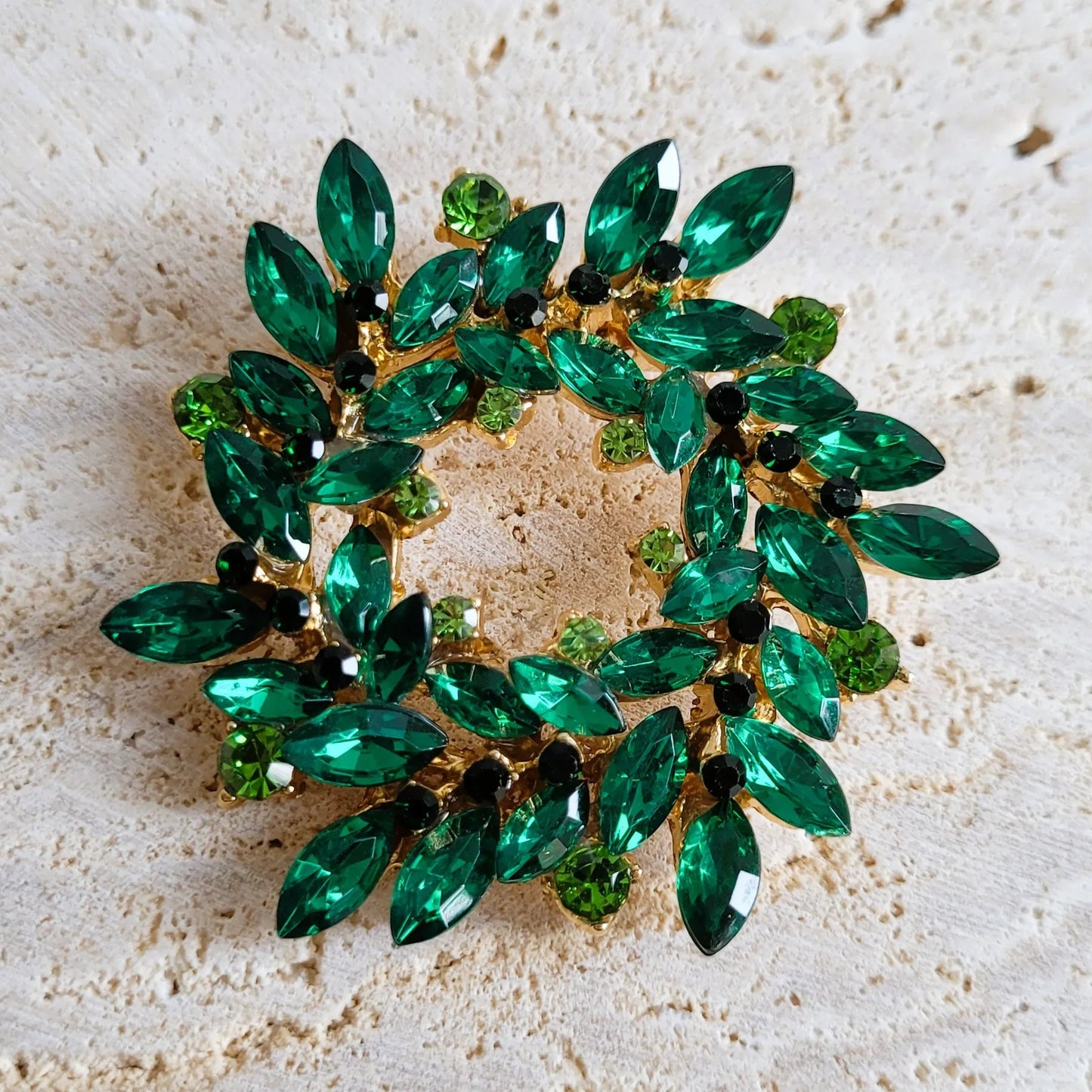 broche dorée Merveilleuse, un bijou moderne en forme de couronne de strass verte