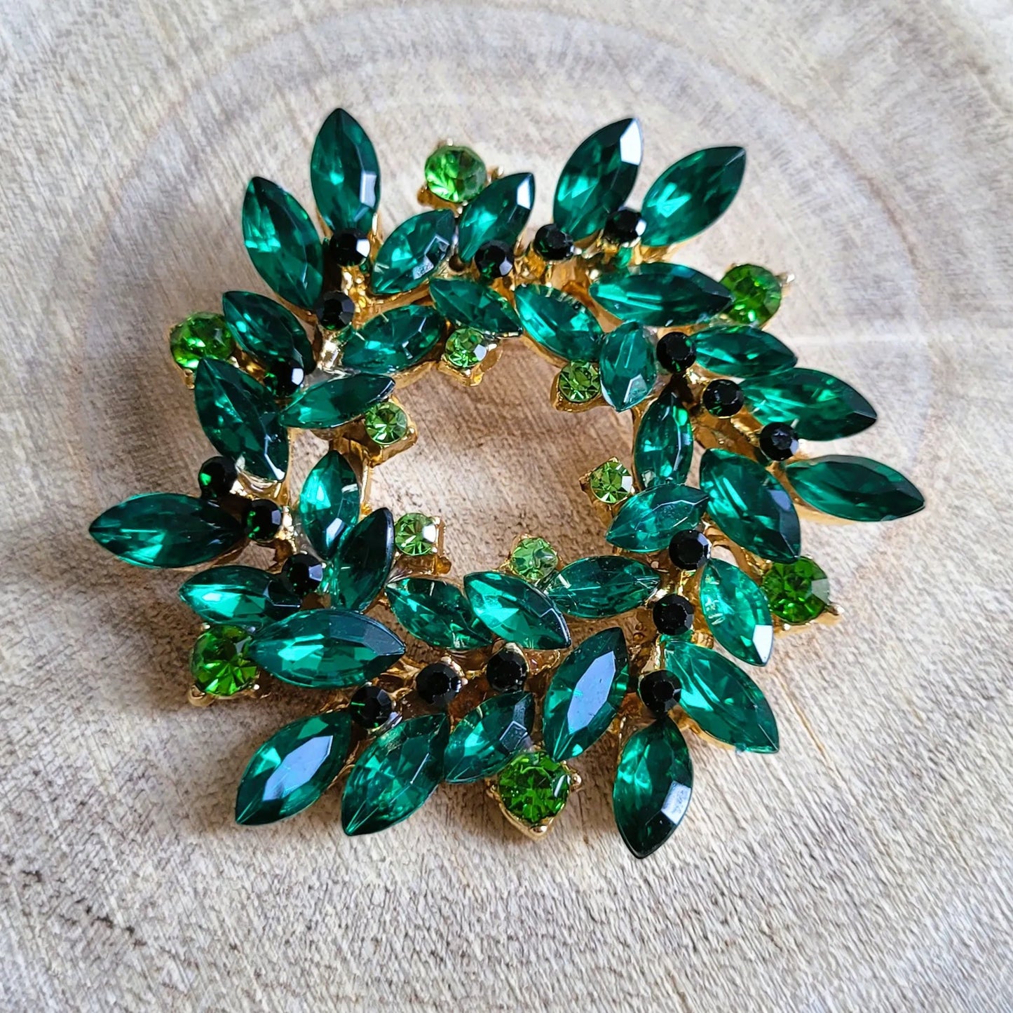 une broche dorée Merveilleuse de luxe en couronne de strass verte