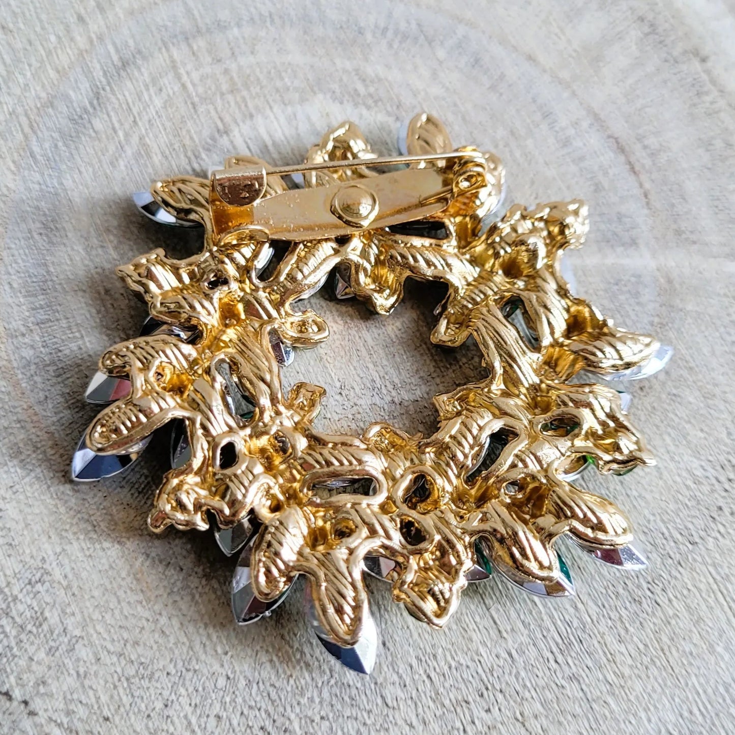 une broche dorée Merveilleuse en couronne de strass verte pour sublimer un petit haut