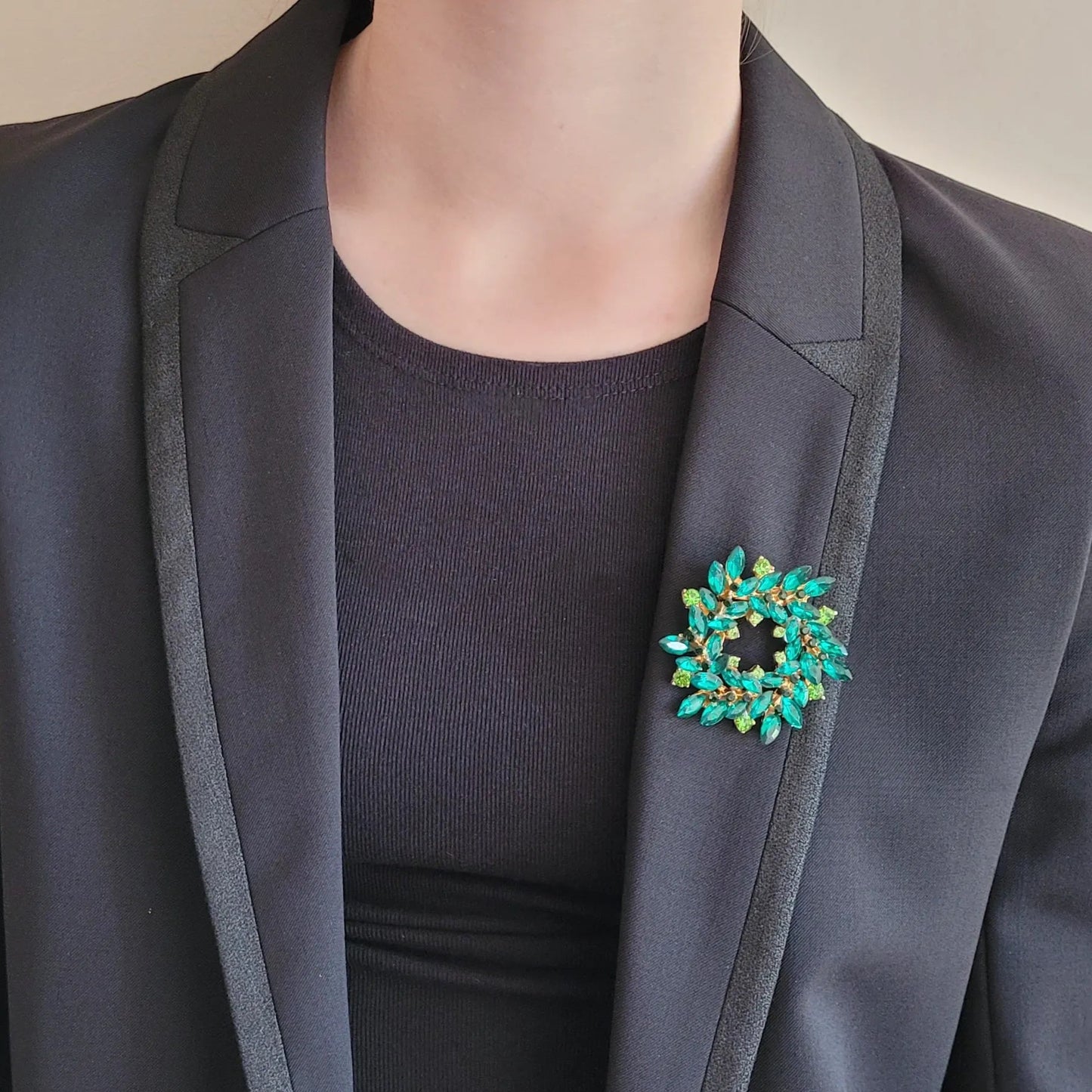 broche dorée Merveilleuse, une broche en forme de couronne de strass verte pour vêtement de femme
