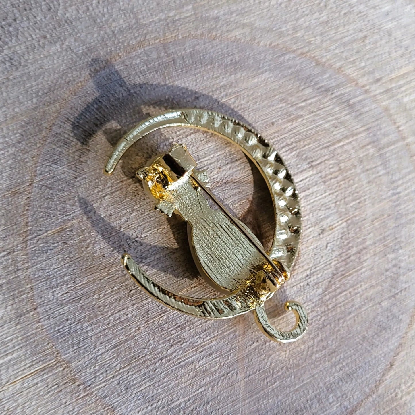 une broche dorée Mooncatz d’un chat rêveur sur un croissant de lune pour sublimer un petit haut