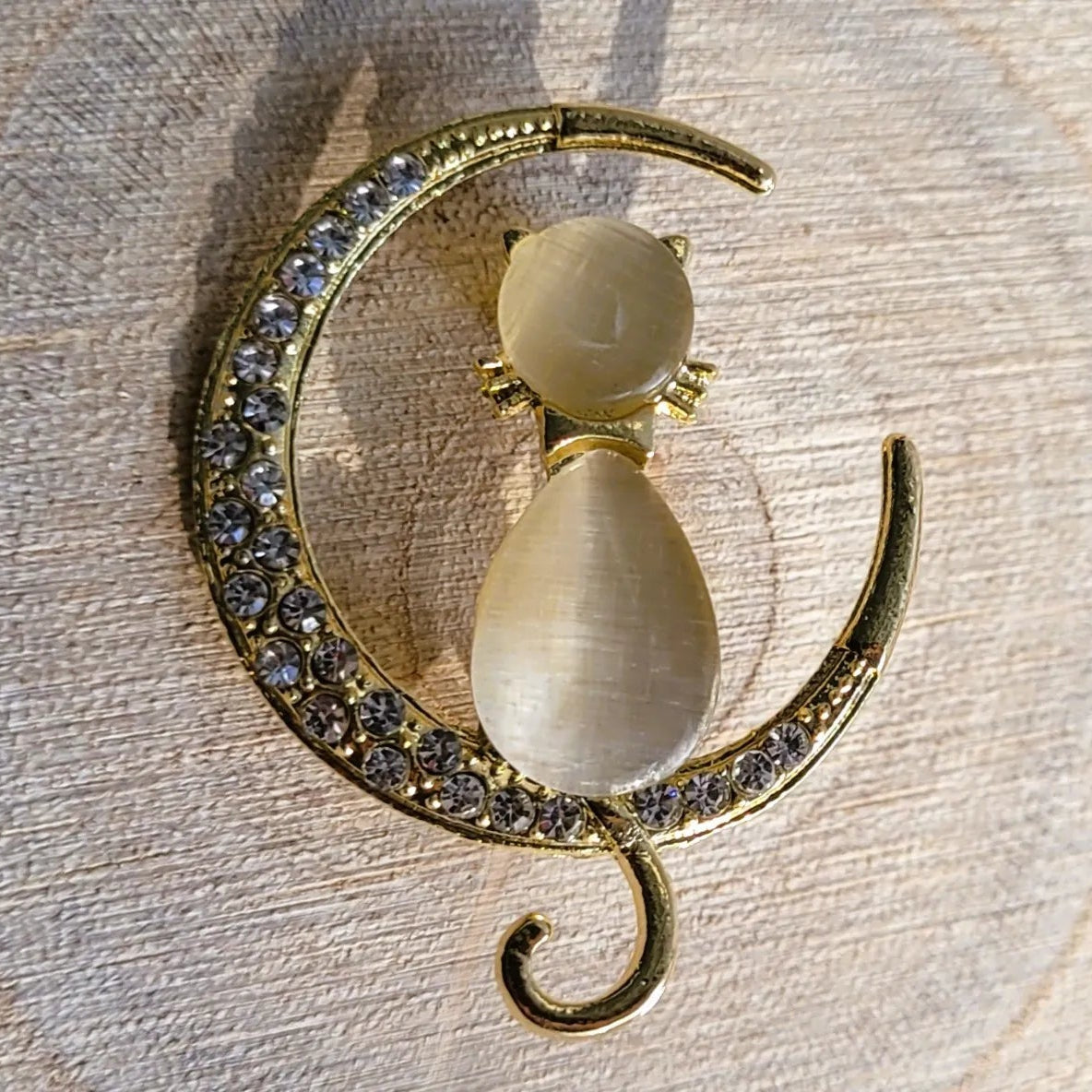 broche dorée Mooncatz d’un chat rêveur sur un croissant de lune de la collection de broches bijoux