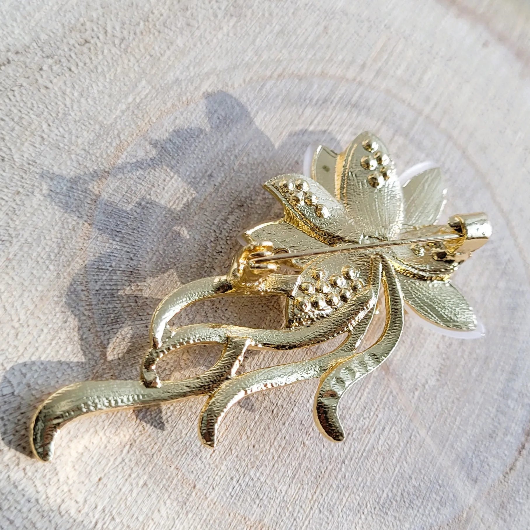 broche dorée Orphéa, un bijou moderne d’une fleur aux délicates longues tiges