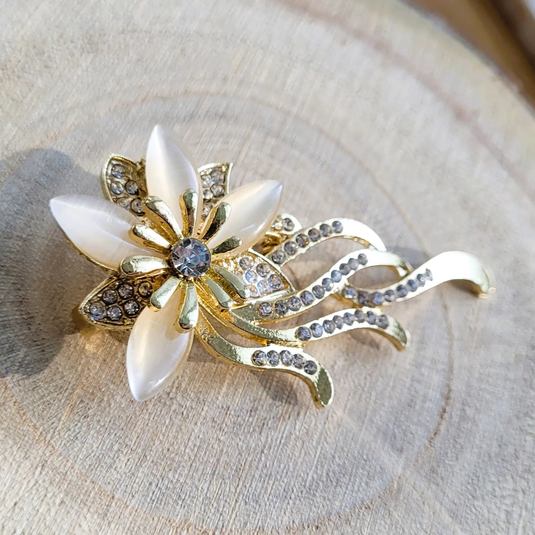 une broche dorée Orphéa d’une fleur aux délicates longues tiges pour sublimer un petit haut