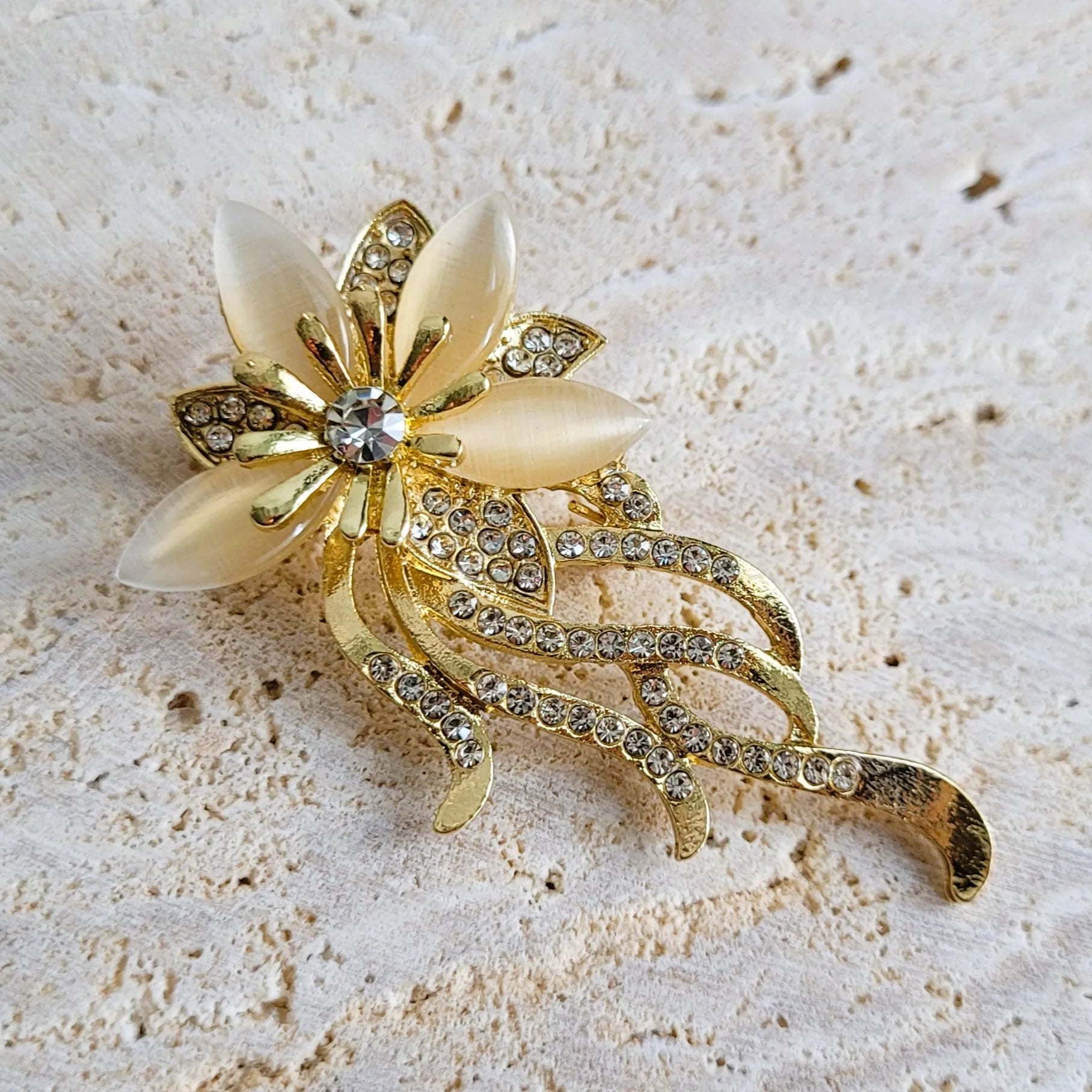 broche dorée Orphéa, une broche d’une fleur aux délicates longues tiges pour vêtement de femme