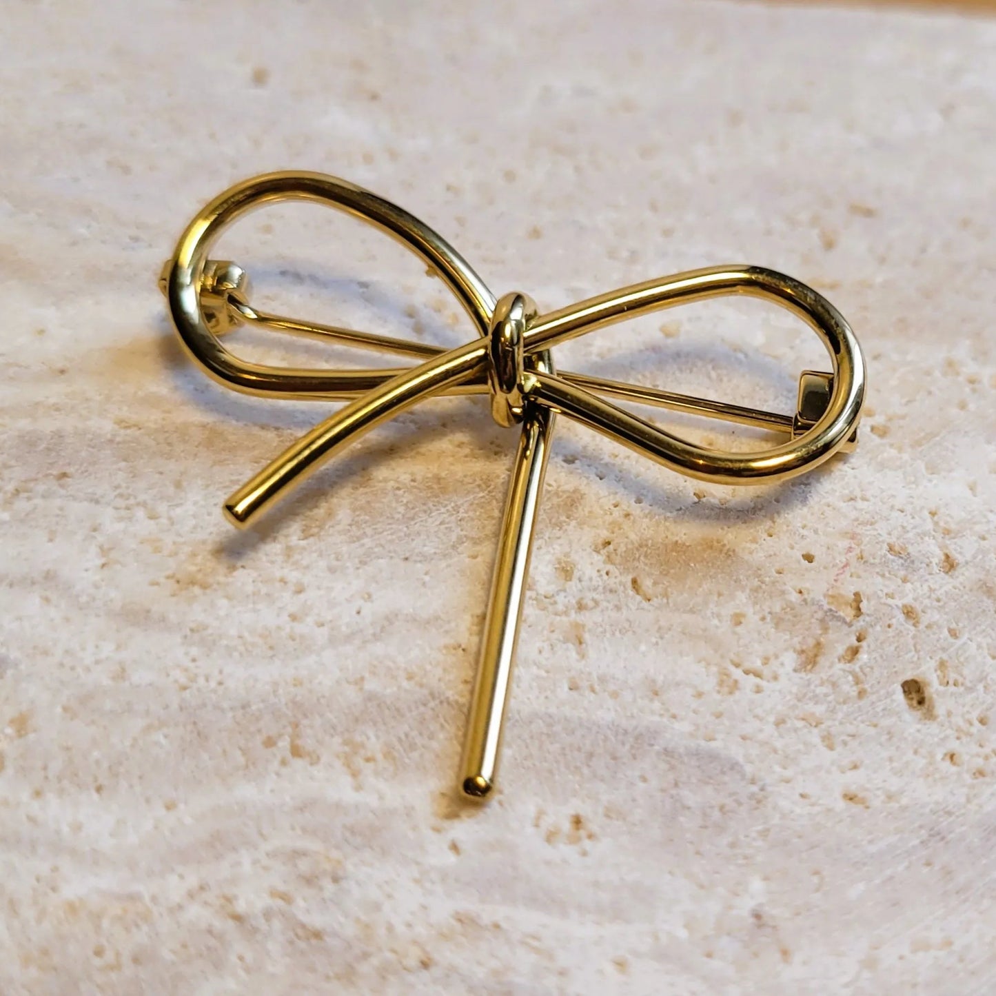 broche dorée Pleasure, une broche d’un nœud délicat pour vêtement