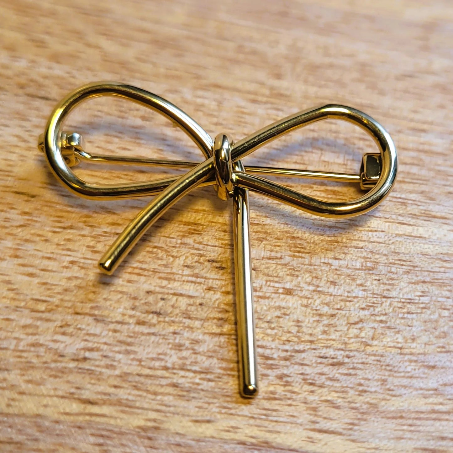 broche dorée Pleasure, une broche en acier inoxydable pour vêtement de femme