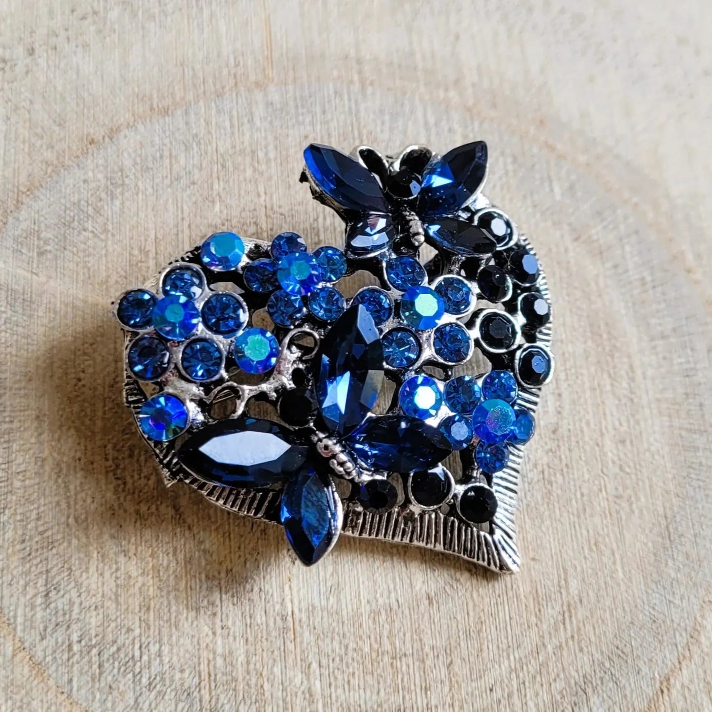 une broche dorée Sentimientos d’un cœur de papillons et de strass bleus pour sublimer un petit haut
