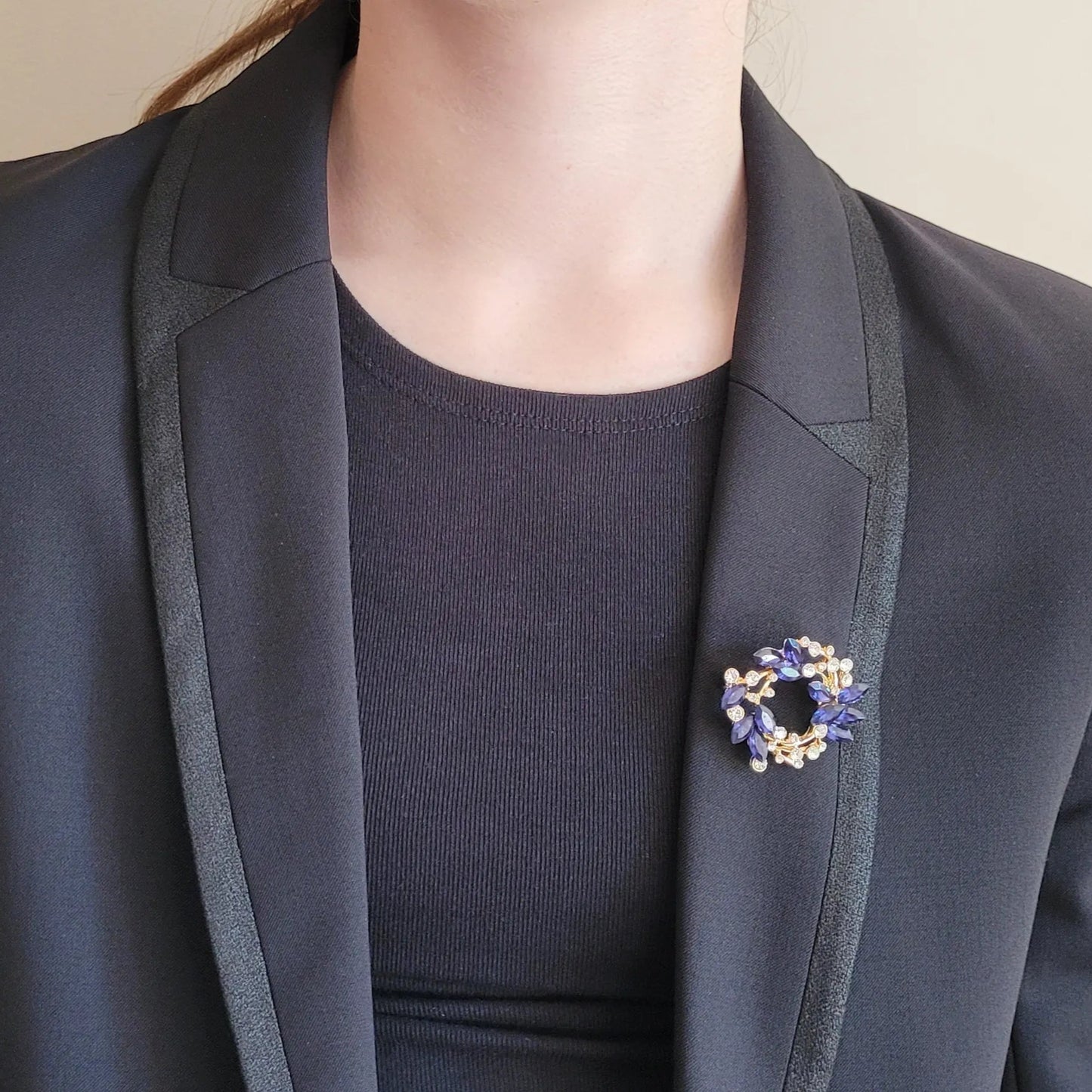 broche dorée Sublim, une broche en forme de couronne de strass bleus et cristal pour vêtement de femme