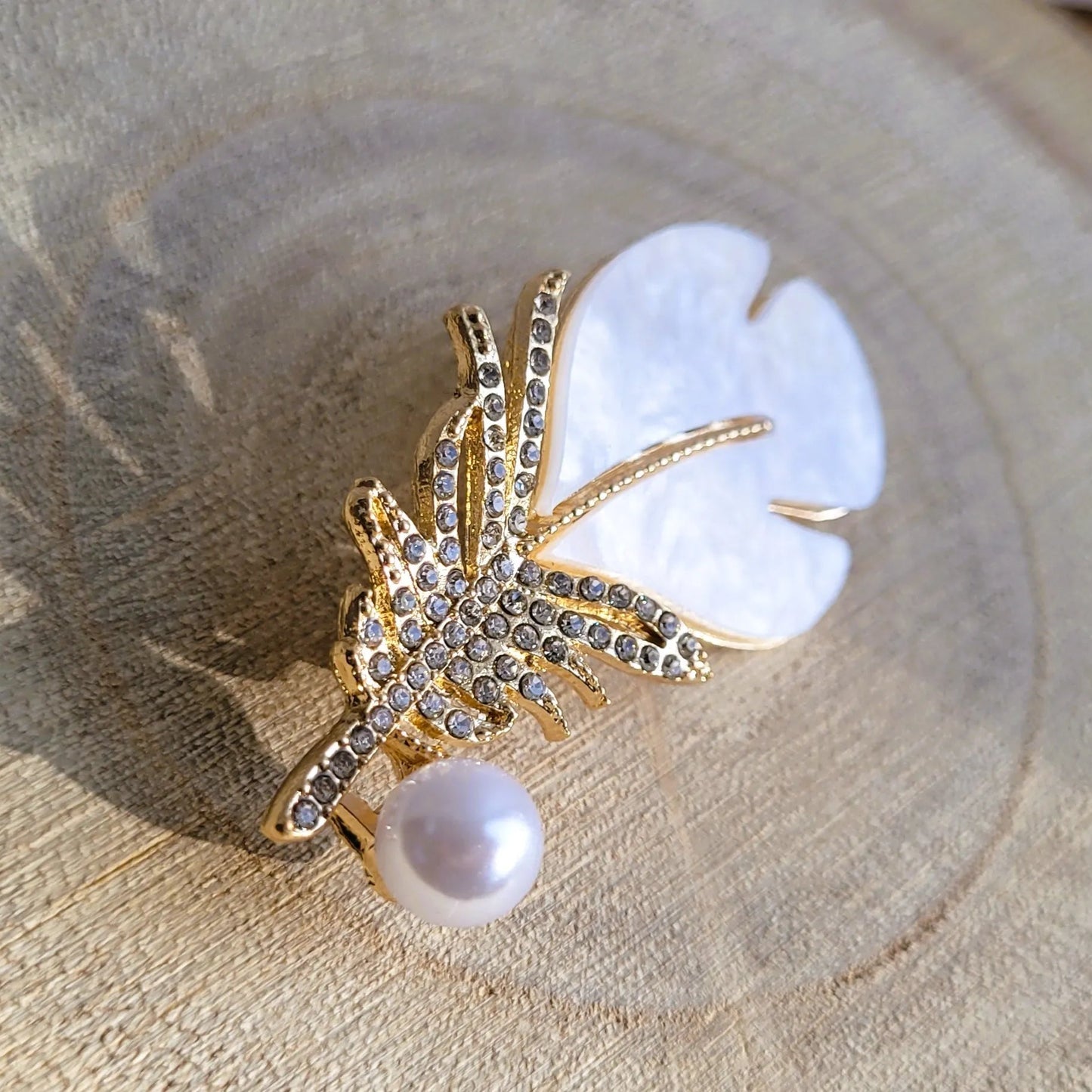 une broche dorée Sweet de luxe d’une plume et de sa perle nacrée délicate