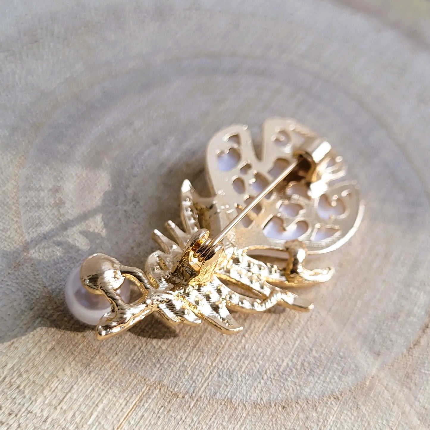 une broche dorée Sweet d’une plume et de sa perle nacrée délicate pour sublimer un petit haut