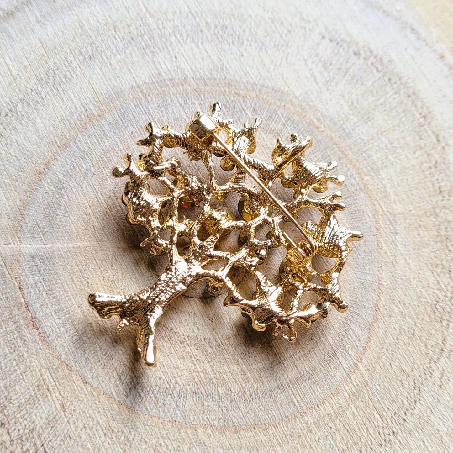 une broche dorée Via d’un arbre de vie aux strass multicolores pour sublimer un petit haut