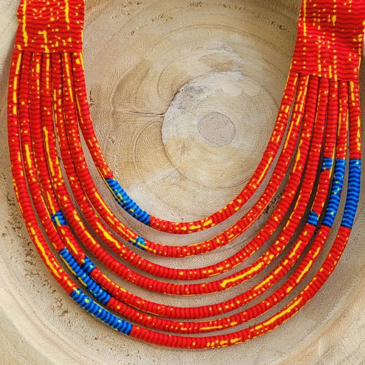 collier en tissu Aïcha, un collier coloré composé de sept rangs de cordons recouverts de tissu wax