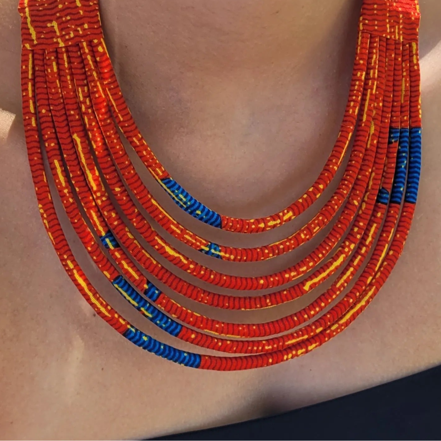 collier en tissu Aïcha, un collier ethnique chic composé de sept rangs de cordons recouverts de tissu wax