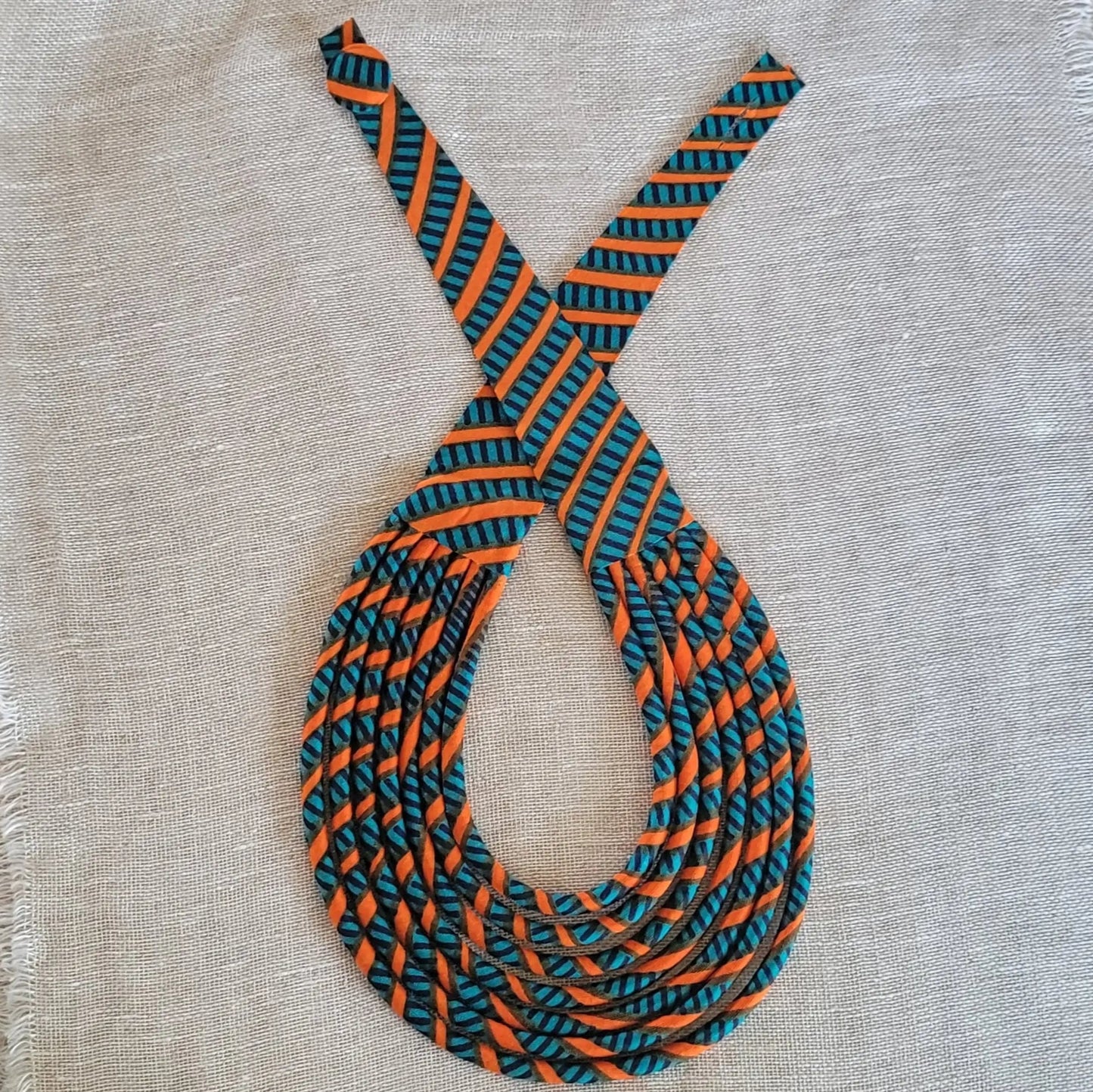 collier en tissu Aminata, un bijou africain traditionnel en pagne vert canard et orange