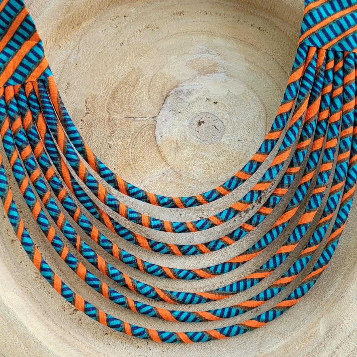 collier en tissu Aminata, un collier coloré composé de sept rangs de cordons recouverts de tissu wax