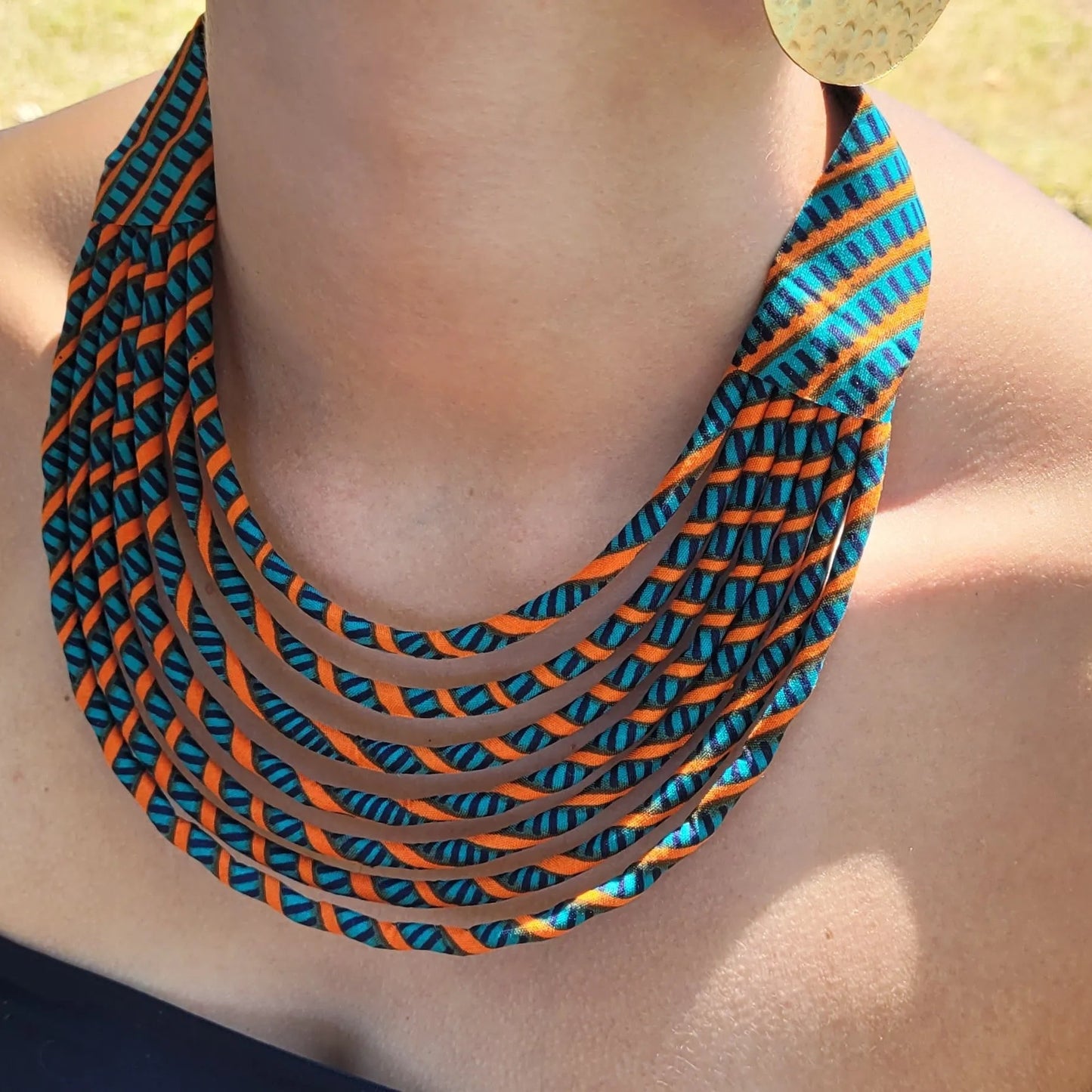 collier en tissu Aminata, un collier ethnique chic en pagne vert canard et orange