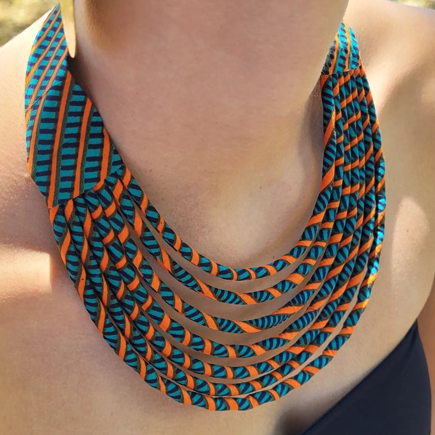 collier en tissu Aminata, un collier ethnique chic composé de sept rangs de cordons recouverts de tissu wax
