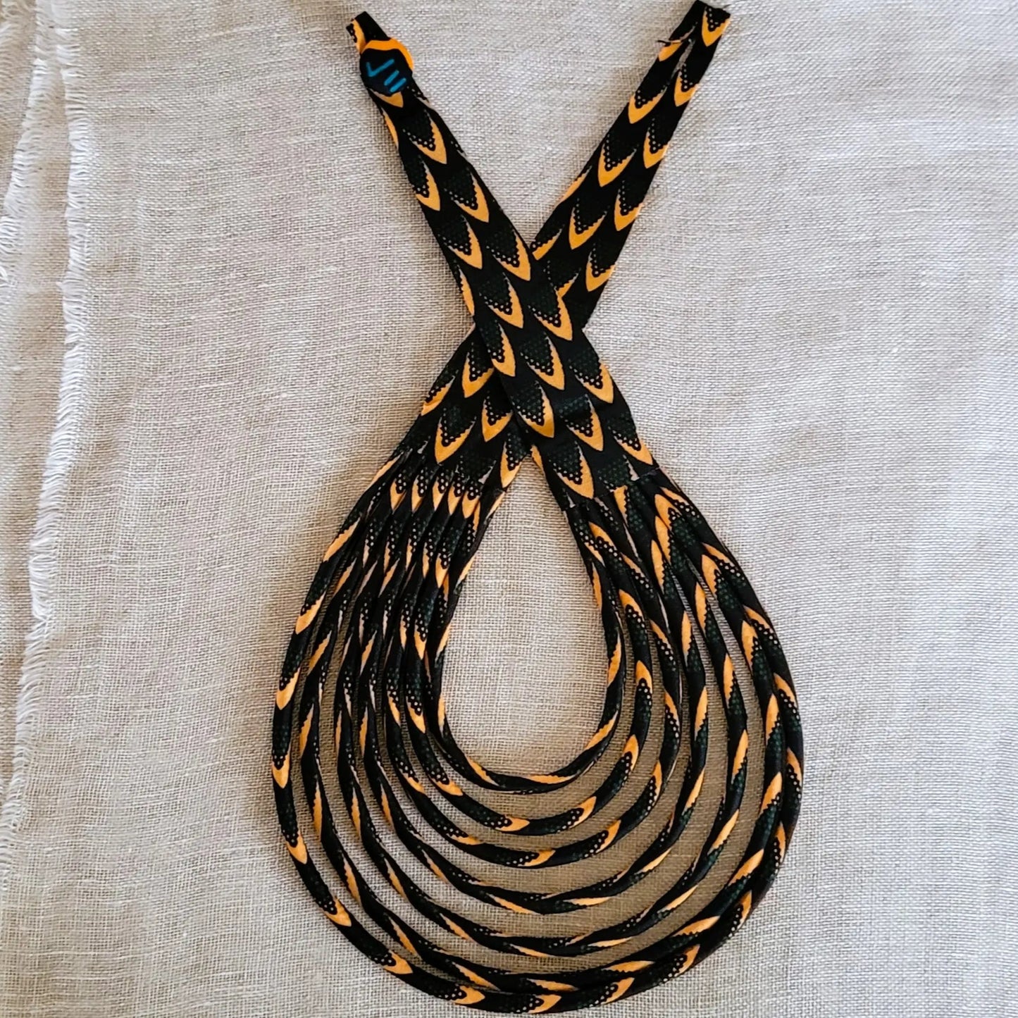 collier en tissu Astou, un bijou africain traditionnel en pagne noir et abricot