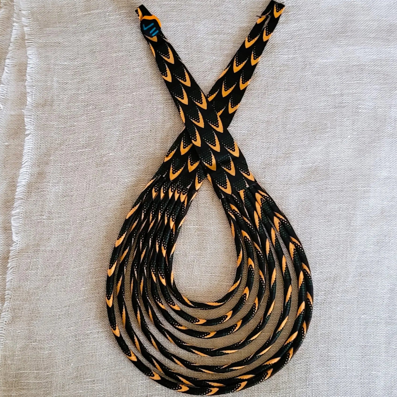 collier en tissu Astou, un bijou africain traditionnel en pagne noir et abricot