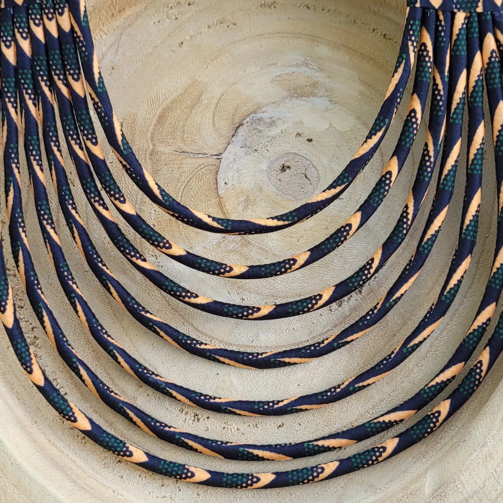 collier en tissu Astou, un collier coloré composé de sept rangs de cordons recouverts de tissu wax