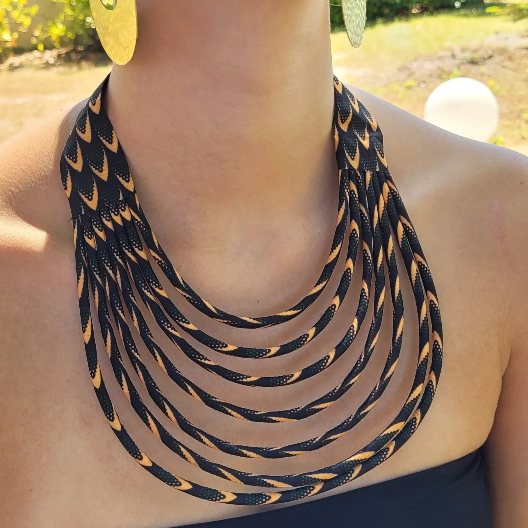 collier en tissu Astou, un collier ethnique chic composé de sept rangs de cordons recouverts de tissu wax