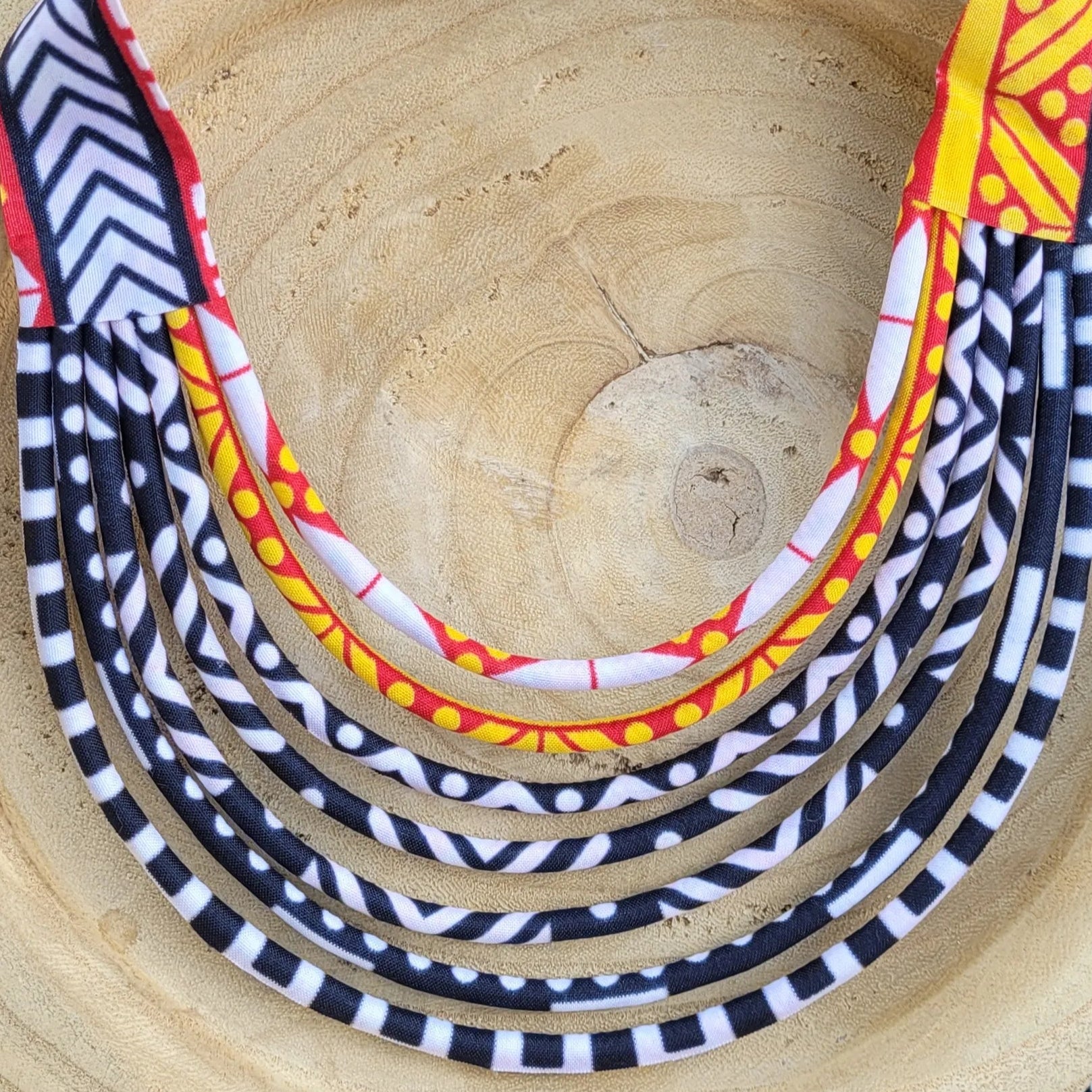 collier en tissu Coumba, un collier coloré composé de sept rangs de cordons recouverts de tissu wax
