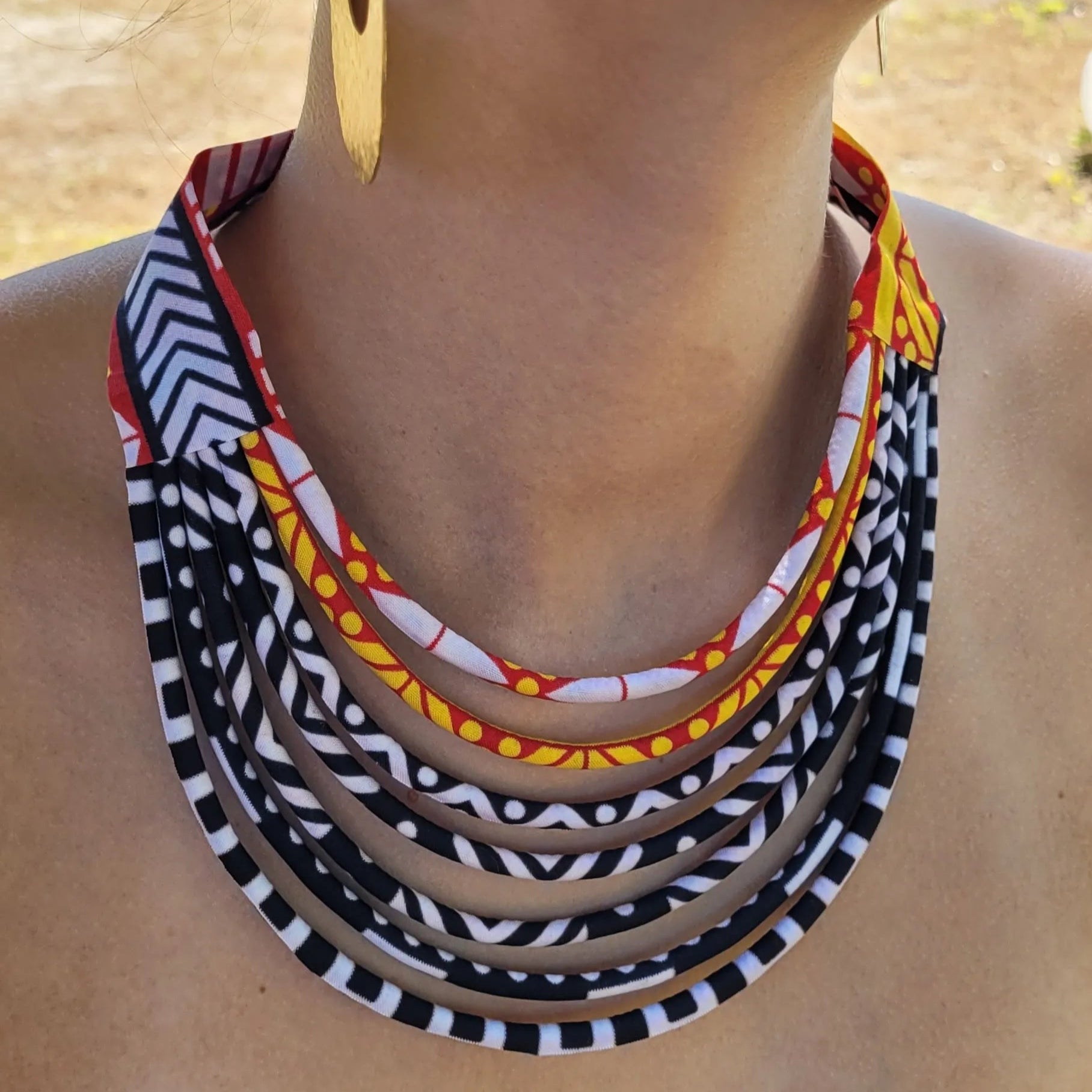 collier en tissu Coumba, un collier ethnique chic composé de sept rangs de cordons recouverts de tissu wax