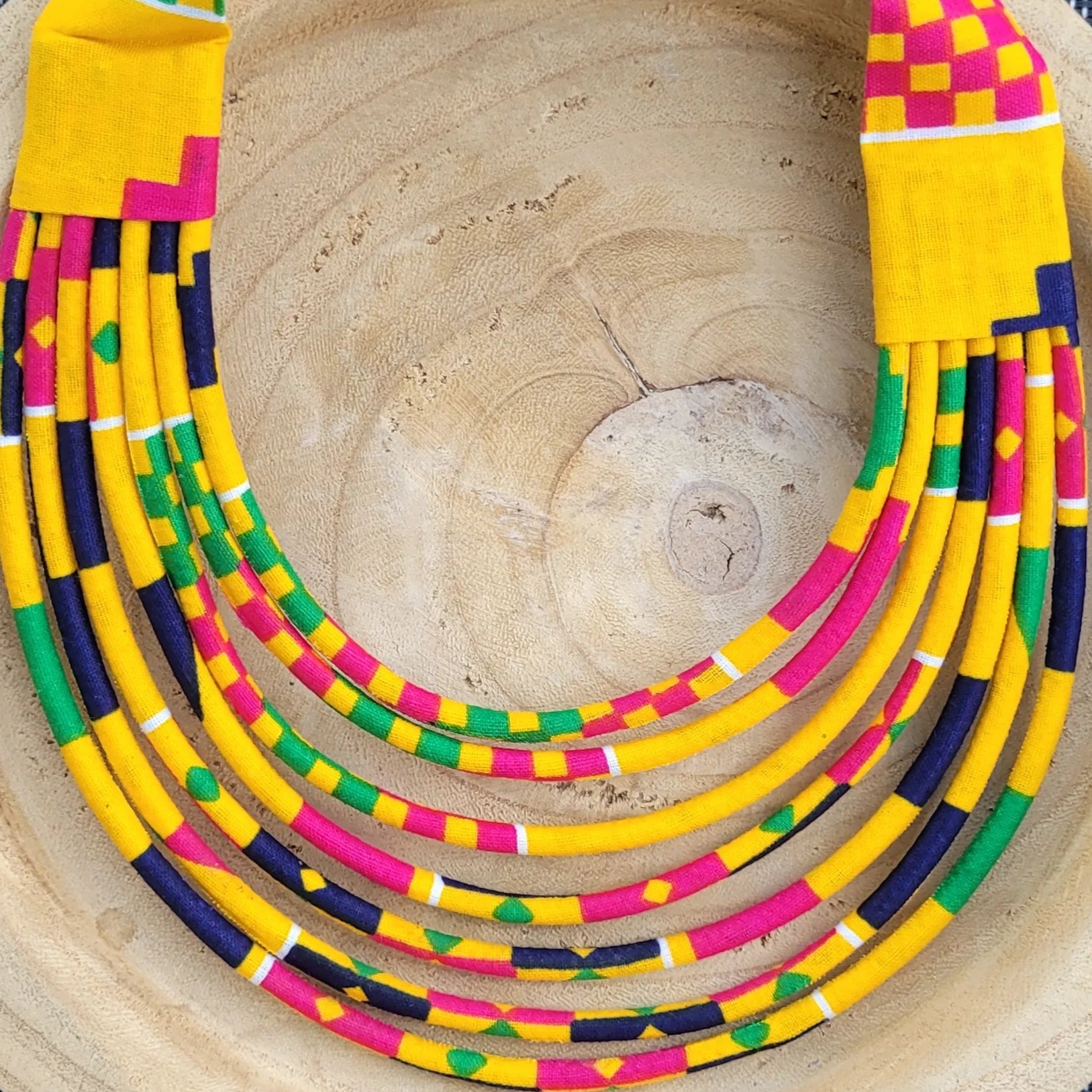 collier en tissu Daba, un collier coloré composé de sept rangs de cordons recouverts de tissu wax