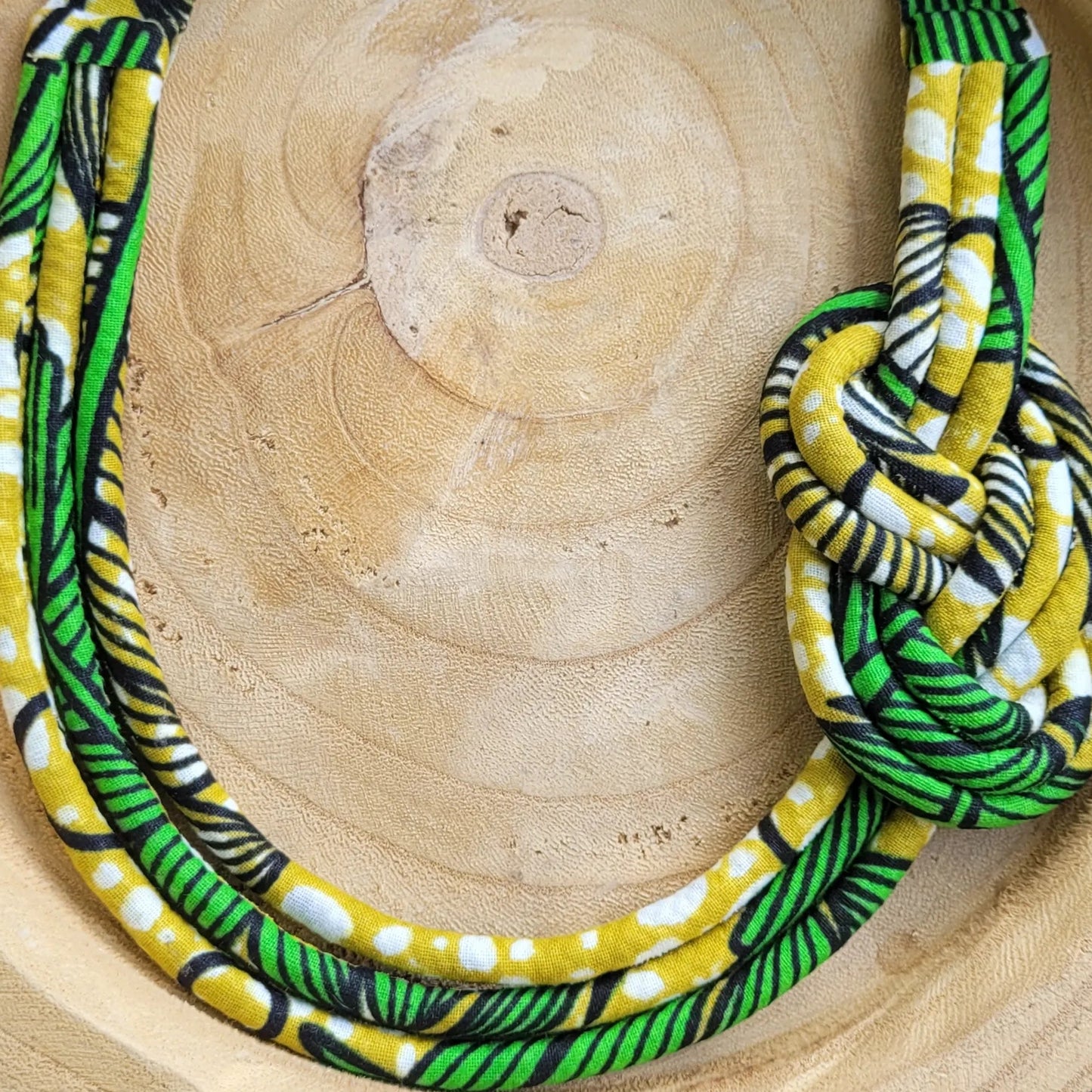 collier en tissu Dieynaba, un collier coloré composé de trois rangs de cordons recouverts de tissu wax entrelacés