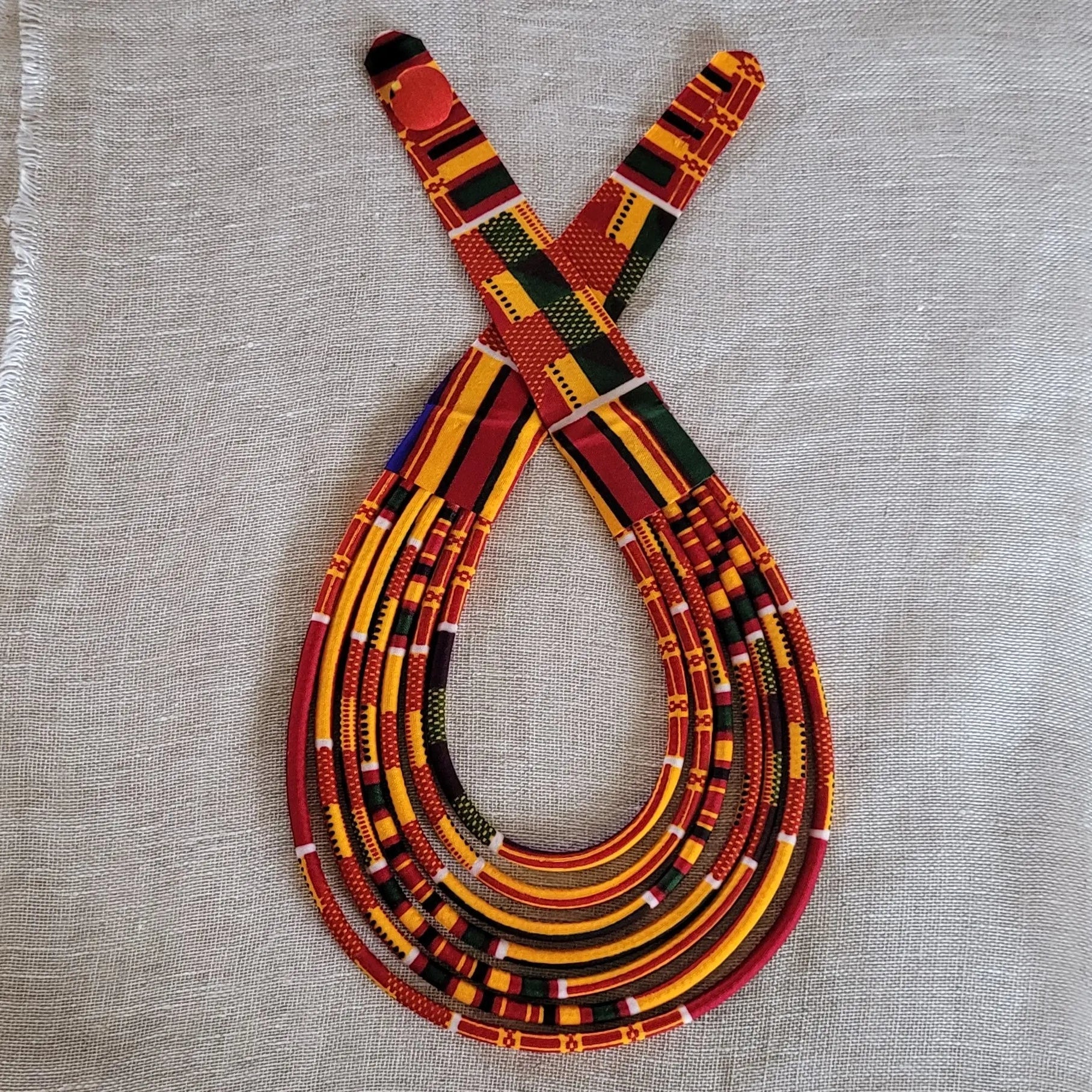 collier en tissu Fatou, un bijou africain traditionnel en pagne orangé et bordeaux