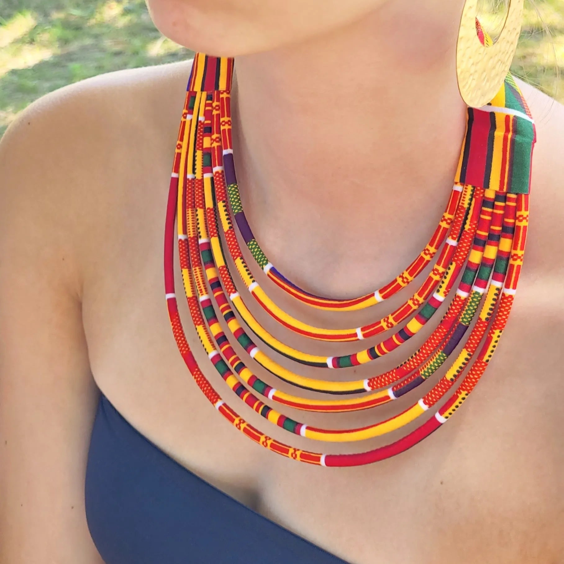 collier en tissu Fatou, un collier coloré en wax orangé et bordeaux